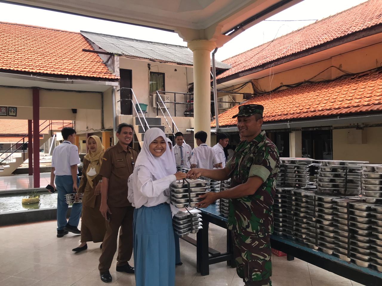 Hadir Ditengah Pelajar, Babinsa Jemur Wonosari Bantu Salurkan Makan Gratis Bergizi di SMA 10 Surabaya