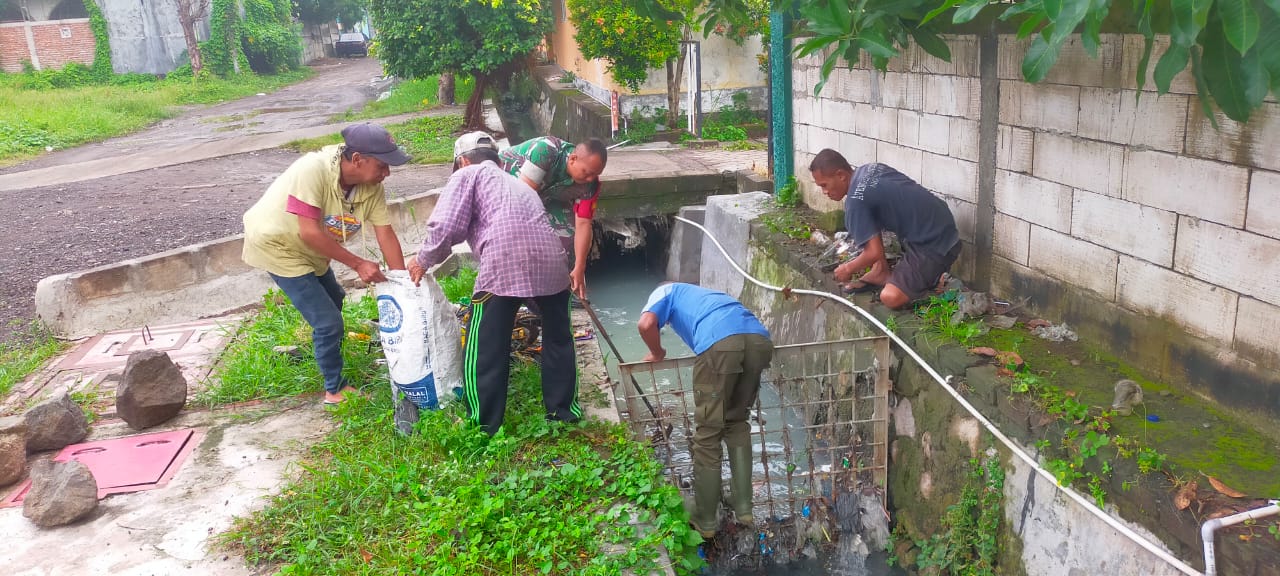 Dengan Semangat Gotong Royong Babinsa Lidah Wetan Bersama Warga Bersihkan Selokan untuk Cegah Banjir.